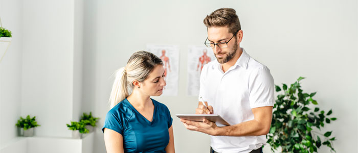 a man with a clipboard talking to a woman